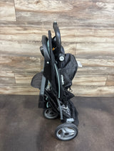 Side view of Baby Trend EZ Ride Stroller in Doodle Dots showcasing folded frame and wheels on a wood-look floor