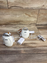 Top view of VTech DM221 audio monitor set showing baby unit speaker, parent unit clip, and power adapter on wood floor