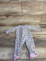 Flat lay of Child Of Mine purple floral footed sleeper showing long sleeves and pink foot cuffs on wood floor background
