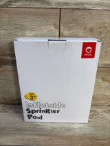 Front view of QPAU Pink Elephant box reading Inflatable Sprinkler Pool with QPAU logo and Age 3+ label on wood background