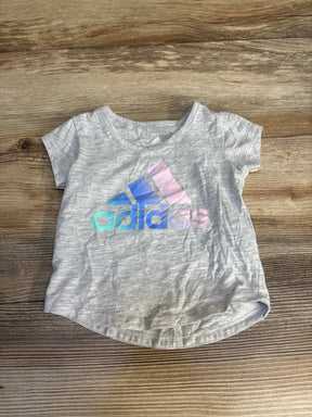 Light gray short sleeve Adidas kids t-shirt with pastel rainbow logo on wooden background