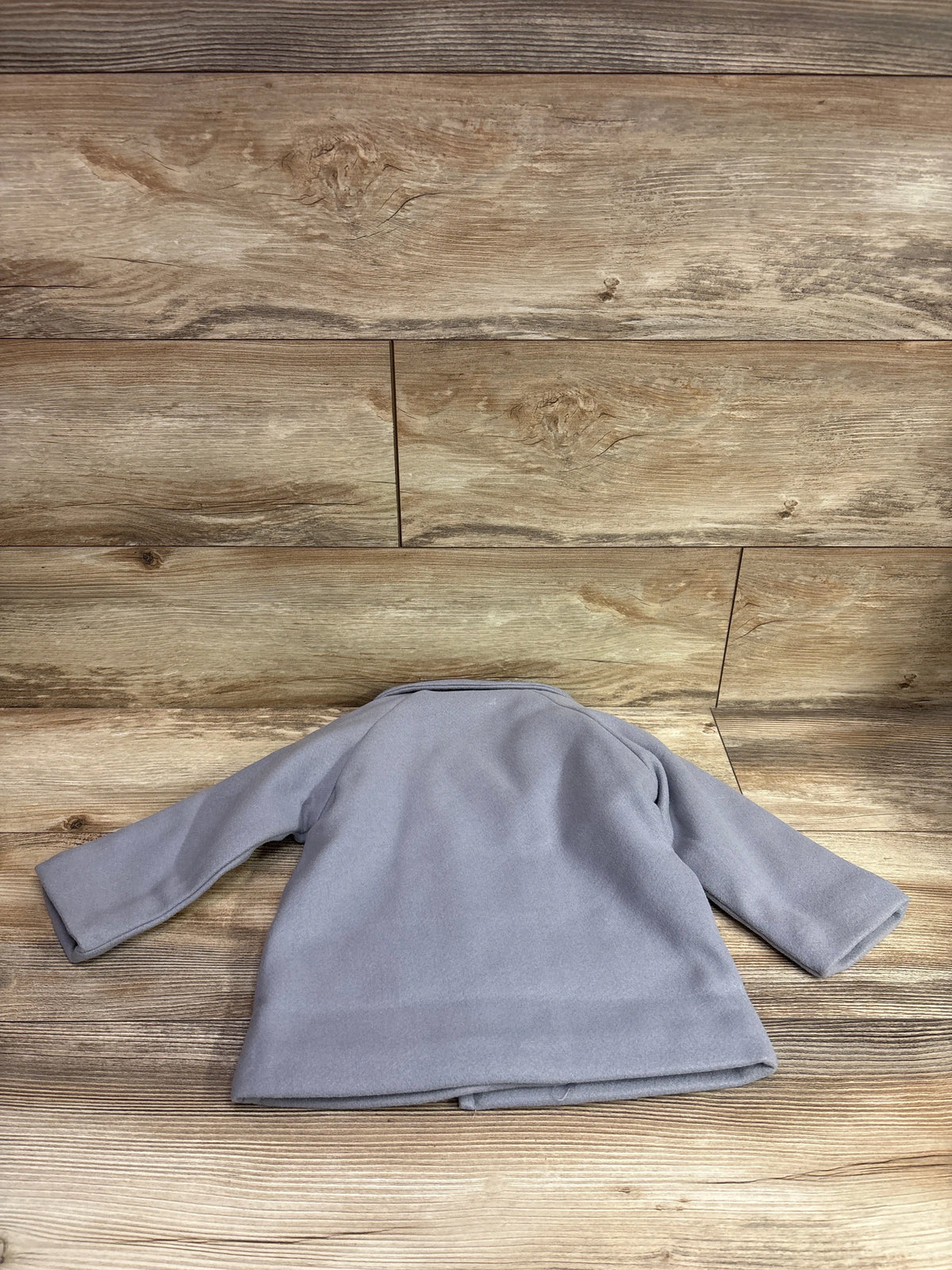 Grey FAIWAD wool trench coat for toddlers size 2/3T on a rustic wood background