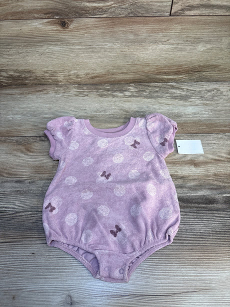 Light pink baby girl romper with white polka dots and bow pattern on wood background