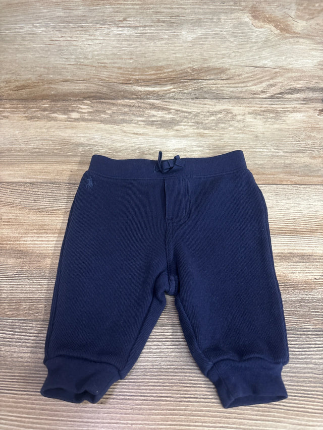 Flat lay of navy Ralph Lauren baby joggers, 3M, showing cuffed ankles, drawstring waistband and pony logo on wood background