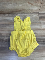 Flat lay of Cat & Jack yellow ribbed bubble romper with ruffle straps, elastic waist and ruffled leg openings on wood floor