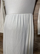 White long sleeve maternity dress with gathered waist, displayed on wood background