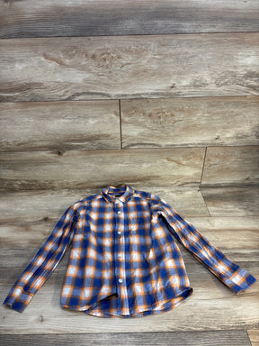 Boys long sleeve orange and blue plaid button-up shirt on wood background