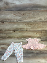 Infant girl floral pants and ruffled pink short sleeve dress outfit on wooden background