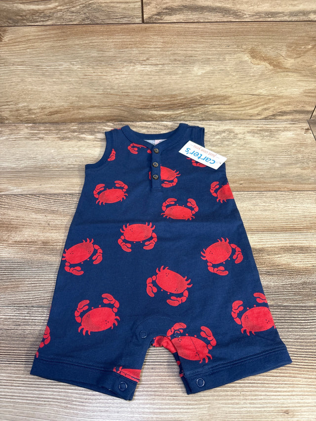 Top-down view of navy Henley shortie romper showcasing red crab print, henley buttons and snap crotch on wood background