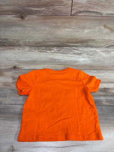 Back view of orange Halloween shirt in size 12 months with a plain back on a wood grain surface