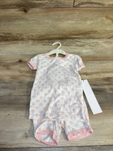 Front flat lay of Milkberry 2-piece bamboo baby pajama set (12 months) showcasing peach daisy print and pink trim on wood floor background