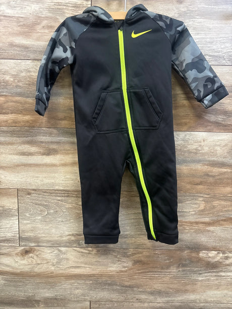 Front view of Nike Therma Fit hooded coverall, black with camo sleeves, neon zipper and pockets on wood floor, size 18 months