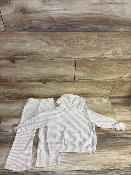 Top-down view of light gray ribbed baby hoodie and matching pants set showcasing ribbed texture and hood on wood background
