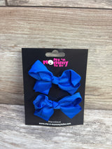Front view of two royal blue grosgrain hair bows on a black Me n Mommy To Be display card against a light wood background