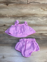 Pink ruffle baby girl top and bloomers set on wood background, kids clothes resale