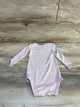 Light pink long sleeve baby bodysuit on wooden background, gently used kids clothing