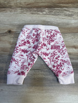 Pink and white baby pants with scenic toile print on wood background
