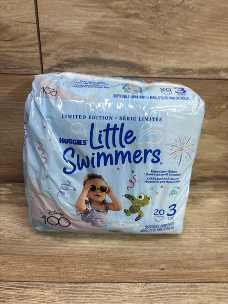 Front view of Huggies Little Swimmers disposable swim pants size 3 20 count with easy open sides on a wood background