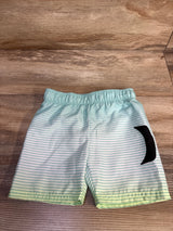Front view of boys' Hurley swim trunks with light blue-and-white stripes, elastic waist, and black logo on wood background