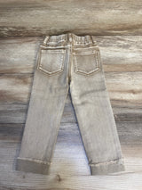 Light brown kids jeans with back pockets, elastic waist, and frayed cuffs on wood background