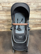 Maxi-Cosi Siena CP stroller with grey seat, black canopy and brown handlebar on wood floor