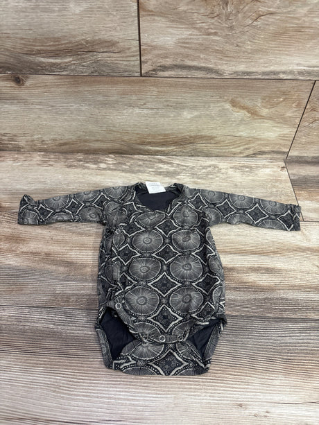 Top view of The Woods Beechwood kimono bodysuit in grey showing long sleeves and geometric pattern on wood flooring
