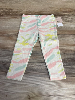 Flat lay of Grayson Mini tie-dye toddler leggings, cream ribbed with pastel pink, mint and yellow stripes on wood