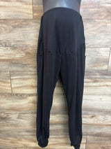 Front view of black maternity leggings with over-bump belly panel, side pockets, and tapered cuffed ankles on a light wood background