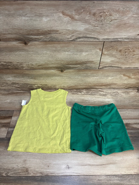 Sleeveless yellow kids shirt and green shorts set on wood background, children's clothing