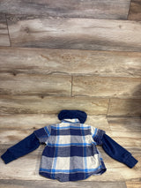 Back view of a blue plaid hooded flannel shacket with navy sleeves, laid flat on a wood floor