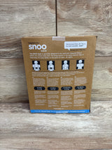 Back view of Happiest Baby SNOO sleep sack packaging showcasing safe-use diagrams and 4 to 6 month sizing on a wood surface