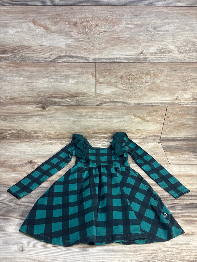 Green and black plaid long sleeve girls dress with ruffle shoulders on wooden floor