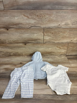 Baby boy clothing set: striped hoodie, pants, and white onesie on wood floor