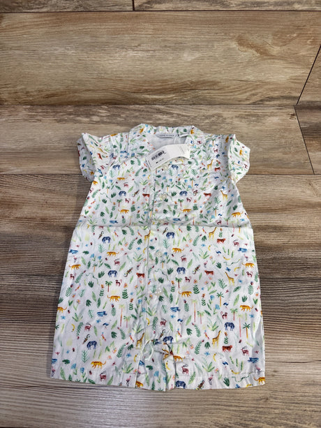 Top-down view of white Janie & Jack shortie romper with small multicolor jungle animal print and front snaps, laid flat on a wood floor