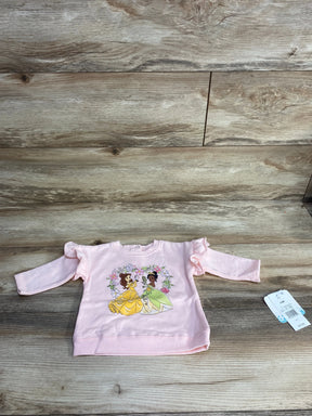 Pink long sleeve toddler shirt with cartoon princess print on wood background