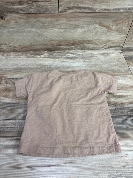 Back view of a beige toddler t-shirt by Me n Mommy To Be on a wooden floor