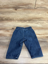 Front view of Easy Peasy pull-on baby jeans (12 months) showing elastic waistband and straight legs on wood background