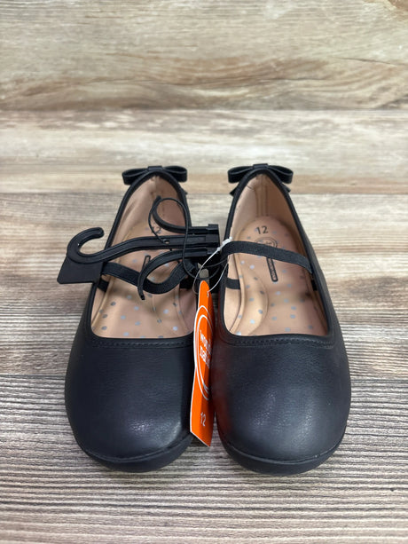 Front view of black Wonder Nation ballet flats, size 12C, with bow details and Mary Jane straps on a wood surface