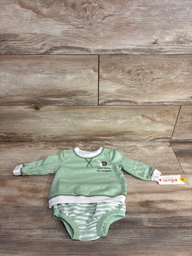 Mint green baby onesie with white striped bottom and snail graphic, laid on wood floor