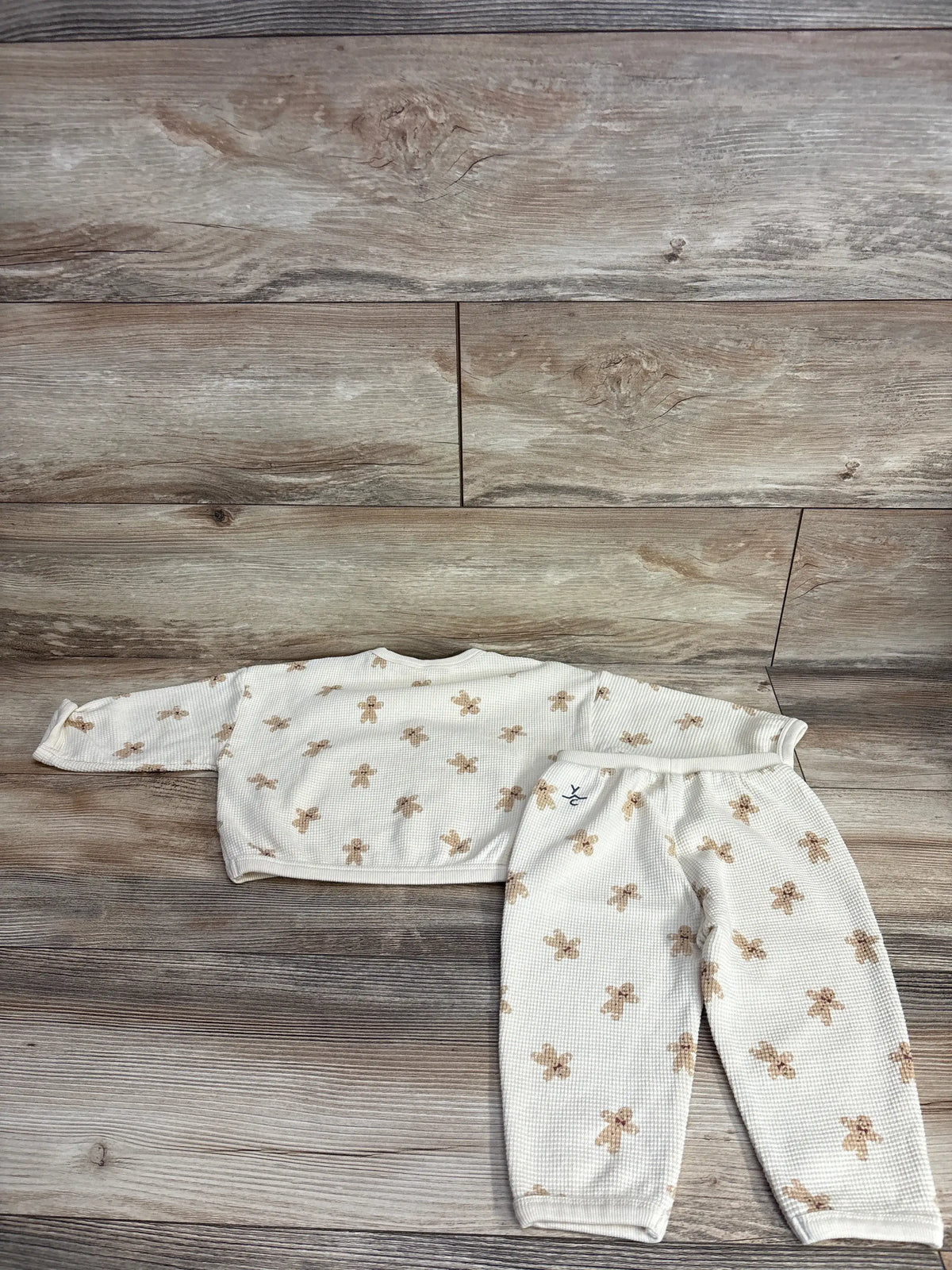 Baby waffle knit pajama set with gingerbread man print, soft toddler sleepwear on wood floor