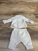 Light gray baby outfit with quilted long sleeve top and pants on wood background