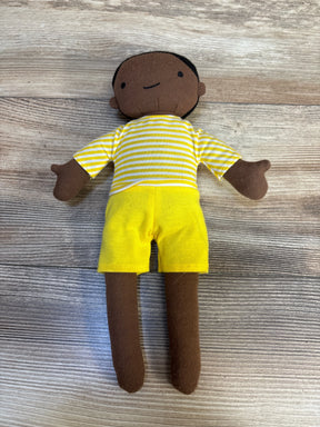 Front view of Cloud Island Plush Doll showcasing brown knit skin, yellow-and-white striped shirt and bright yellow shorts on wood plank background