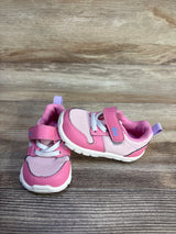 Three-quarter view of pink See Kai Run Tenny toddler sneakers showing mesh upper, velcro strap, elastic laces on wood