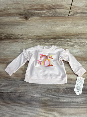 Pink baby sweatshirt with rainbow and birds print on wood floor, tag attached