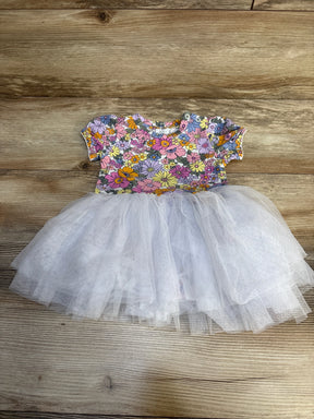 Floral baby dress with tulle skirt, short sleeves, colorful flowers on white, laid on wood floor