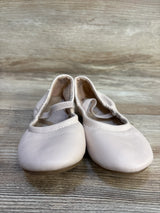 Light pink toddler ballet shoes with elastic straps on wood floor