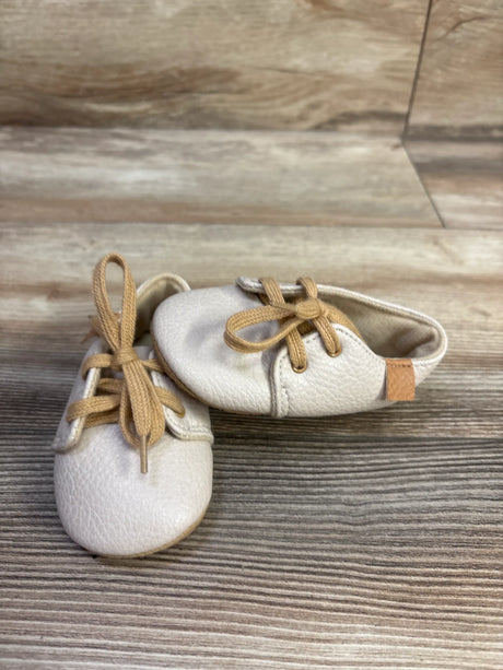Top view of Myggpp beige rubber sole shoes showcasing tan laces and textured uppers with a wood-look background