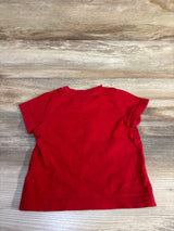 Back view of a red short-sleeved baby shirt by Me n Mommy To Be on a light wood background.
