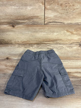 Flat lay of grey toddler cargo shorts with elastic waistband and flap side pockets on wood background