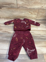 Top down view of maroon Harry Potter two piece sweatshirt and pants set with an all over wizard themed print on wood flooring
